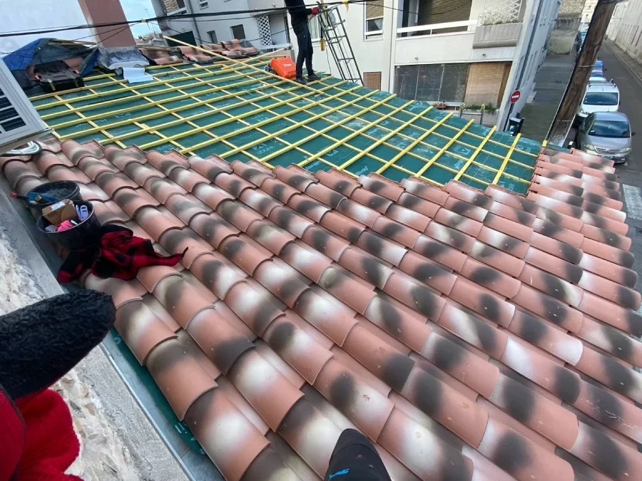 Artisan couvreur réalisant une rénovation de toiture en tuiles à Béziers