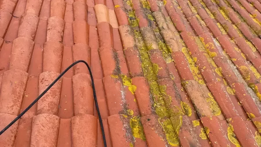 Artisan couvreur nettoyant une toiture à Béziers
